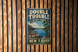 A vintage-style metal sign for Double Trouble State Park in New Jersey, featuring a scenic landscape with a lake and mountains.