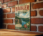A vintage-style metal sign for Dr. Edmund A. Babler Memorial State Park in Missouri, featuring a scenic landscape with a lake and mountains.