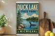 A vintage-style sign for Duck Lake State Park in Michigan, featuring a lake scene with a loon and trees in the background.