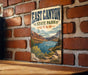 A vintage-style metal sign displaying the name "East Canyon State Park Utah" is mounted on a brick wall.