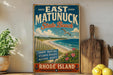 A vintage-style sign for East Matunuck State Beach, featuring a beach scene with a wooden fence, a bird, and a blue sky with clouds.