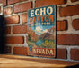 A vintage-style metal sign for Echo Canyon State Park in Nevada, featuring a scenic landscape with mountains, a lake, and desert vegetation.