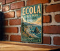 A vintage-style metal sign for the Oregon Coast State Park, featuring a scenic coastal landscape with mountains, trees, and the ocean.