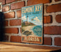 A vintage-style metal sign for Egmont Key State Park in Florida, featuring a lighthouse and a turtle on a beach.