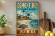 A vintage-style metal sign for Egmont Key State Park in Florida, featuring a lighthouse, palm trees, and a turtle on a beach.