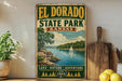A vintage-style sign for El Dorado State Park in Kansas, featuring a scenic landscape with a lake, trees, and a sailboat.