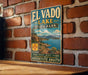 A vintage-style metal sign for El Vado Lake State Park, featuring a scenic landscape with mountains, water, and a boat.