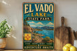 A vintage-style sign for El Vado Lake State Park, featuring a scenic landscape with mountains, a lake, and a boat, along with the text "El Vado Lake State Park" and "Adventures Await".