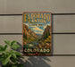 A vintage-style sign for Eldorado Canyon State Park in Colorado, featuring a scenic mountain landscape with a river and pine trees.