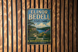 A vintage metal sign for Elinor Bedell State Park, featuring a scenic landscape with a river, mountains, and flowers.
