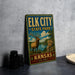 A vintage-style metal sign for Elk City State Park in Kansas, featuring an illustration of a deer in a scenic landscape.