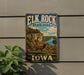 A vintage metal sign for Elk Rock State Park in Iowa, featuring a scenic landscape with a river, cliffs, and a deer.
