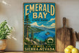 A vintage-style sign for Emerald Bay State Park, featuring a scenic landscape with a lake, mountains, and pine trees.