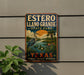 A vintage-style sign for Estero Llano Grande State Park, featuring a large blue heron and a palm tree, with the text "ESTERO LLANO GRANDE STATE PARK" and "TEXAS" prominently displayed.