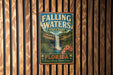 A vintage-style metal sign for Falling Waters State Park in Florida, featuring a waterfall and tropical foliage.