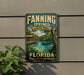 A vintage-style sign for Fannin Springs State Park in Florida, featuring a scenic image of a river, palm trees, and a wooden bridge.