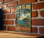 A vintage-style sign for the Farm Island State Recreation Area in South Dakota, featuring a scenic landscape with a lake, trees, and a boat.