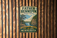 A vintage metal sign for Father Henepin State Park in Minnesota, featuring a scenic illustration of a river and forest.