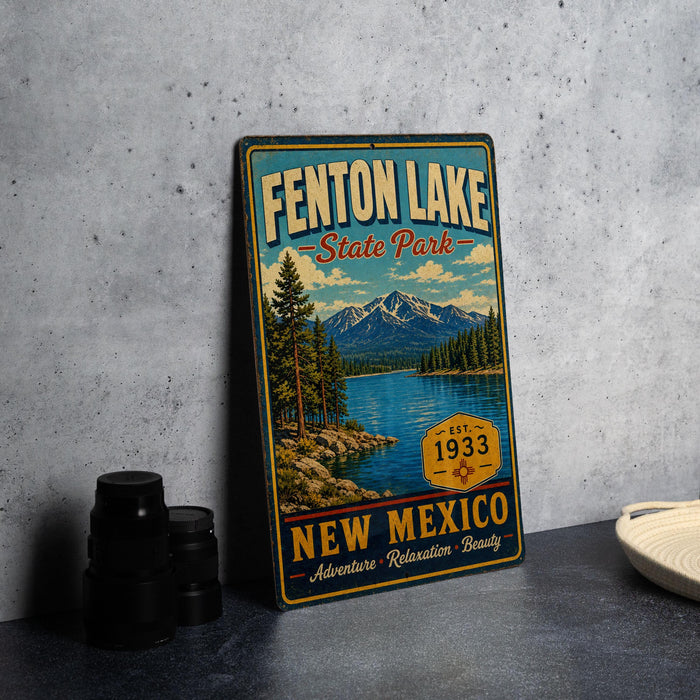 A vintage metal sign for Fenton Lake State Park, featuring a scenic landscape with mountains, a lake, and pine trees.