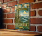 A vintage-style metal sign for Fernne Clyde State Park in Illinois, featuring a scenic landscape with a river and mountains.
