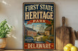 a vintage-style sign for First State Heritage Park in Delaware, with a picture of a historic building and ship on the sign.