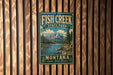 A vintage-style metal sign for Fish Creek State Park in Montana, featuring a scenic mountain landscape with a river and pine trees.