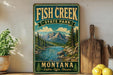 A vintage-style sign for Fish Creek State Park in Montana, featuring a scenic mountain landscape with a river and pine trees.