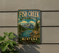 A vintage-style metal sign for Fish Creek State Park in Montana, featuring a scenic mountain landscape with a river and pine trees.