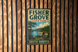A vintage-style metal sign for Fisher Grove State Park in South Dakota, featuring a scenic landscape with pine trees, a lake, and mountains.