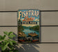 A vintage-style sign for Fish Trap Lake State Park in Kentucky, featuring a scenic image of a lake surrounded by mountains and a boat on the water.