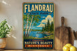 A vintage-style sign for Flandrau State Park in Minnesota, featuring a scenic landscape with birch trees, a lake, and mountains.