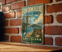 A vintage-style metal sign for Fountainbleau State Park in Louisiana, featuring a scenic illustration of the park's natural surroundings.