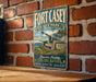 A vintage-style metal sign for Fort Casey State Park in Washington, featuring a scenic image of the park's historical fort and surrounding landscape.