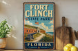 a vintage-style sign for Fort Clinch State Park in Florida, with a picture of the fort and surrounding landscape.