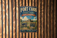 A vintage-style metal sign for Fort Cobb State Park in Oklahoma, featuring a cannon and a sign with the park's name and founding date.