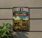 A vintage-style metal sign for Fort Cobb State Park in Oklahoma, featuring a cannon and a sign with the park's name and founding date.