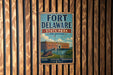 A vintage metal sign for Fort Delaware State Park in Delaware, featuring an illustration of the fort and surrounding landscape.