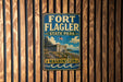 A vintage metal sign for Fort Flagler State Park in Washington, featuring an illustration of the park's landscape and buildings.