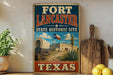 A vintage-style sign for the Fort Lancaster State Historic Site in Texas, featuring an illustration of a wagon and a building with a Texas flag.