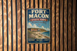 A vintage-style metal sign for Fort Macon State Park in North Carolina, featuring an illustration of the fort and beach.