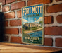A vintage-style metal sign for Fort Mott State Park in New Jersey, featuring an illustration of the fort and surrounding landscape.
