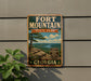 A vintage-style metal sign for Fort Mountain State Park in Georgia, featuring a scenic landscape with a mountain, pine trees, and a river.
