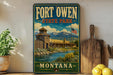 A vintage-style poster of Fort Owen State Park in Montana, featuring a wooden building and a river, is displayed on a wall next to a wooden cutting board and a potted plant.
