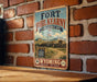 A vintage-style metal sign for the Fort Phil Kearny, a historic site in Wyoming, is displayed on a brick wall.
