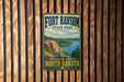 A vintage-style metal sign for Fort Ransom State Park, featuring a scenic landscape with a river and mountains.