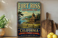 A vintage-style metal sign for Fort Ross State Historic Park in California, featuring a scenic image of a historic building and landscape.