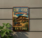 A vintage-style sign for Fort Verde State Historic Park in Arizona, featuring a building and a wagon in a desert landscape.