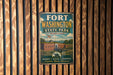 A vintage metal sign for Fort Washington State Park in Maryland, featuring an illustration of the fort and surrounding landscape.