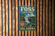 A vintage-style metal sign for Foss State Park in Oklahoma, featuring a waterfall and a forest landscape.