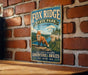 A vintage metal sign for Fox Ridge State Park in Illinois, featuring an illustration of a fox in a natural setting.